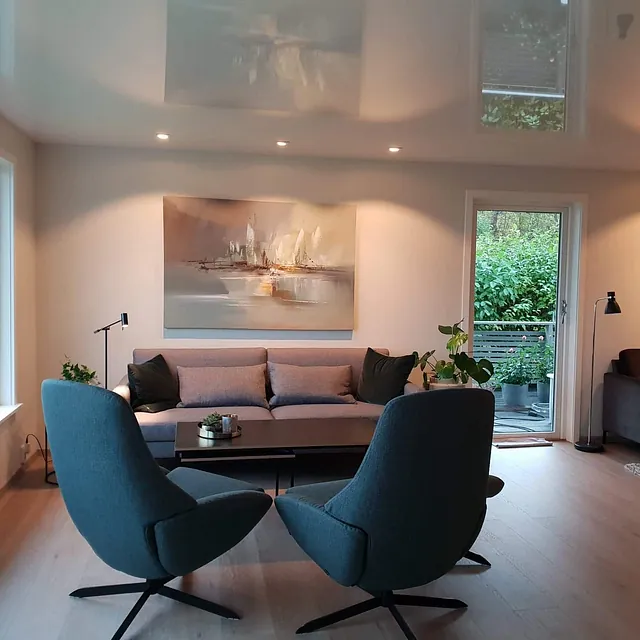 Stue med sofa, lenestoler og utgang til hage